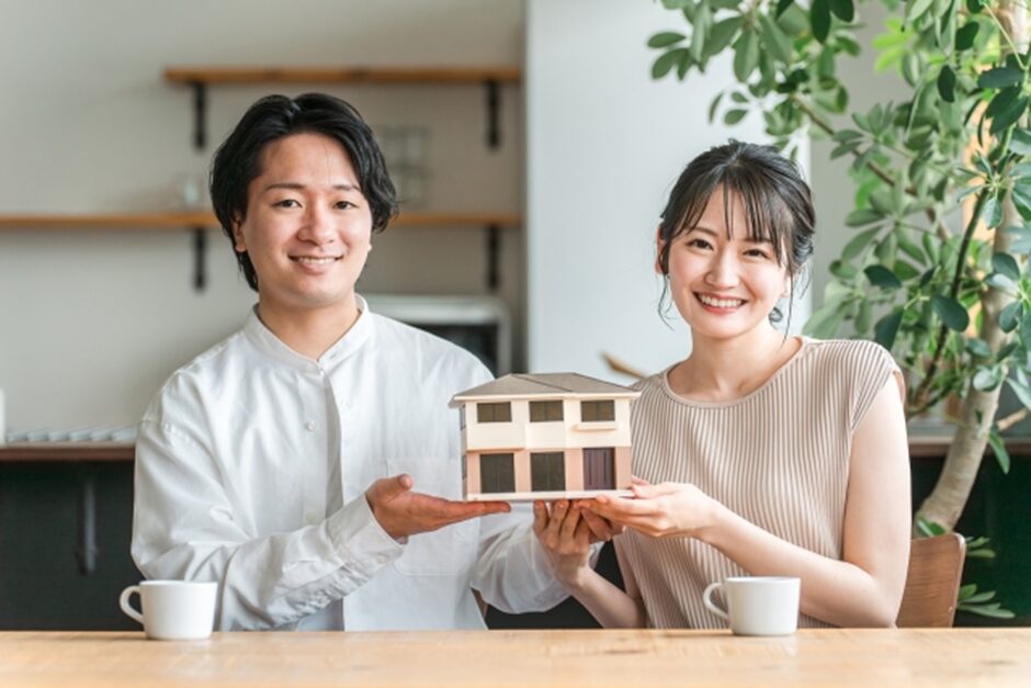 家の模型と若い夫婦